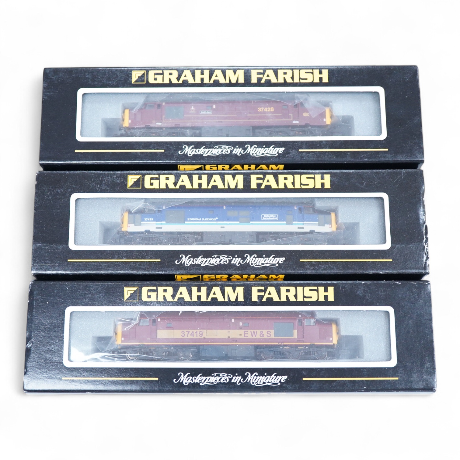 Three boxed Graham Farish N gauge railway Class 37/4 Co-Co diesel-electric locomotives; a Scottish EWS, Loch Awe (371151), a Regional Railways, Eisteddfod Genedlaethol 37429 (371154), and an EWS, 37419 (371153).